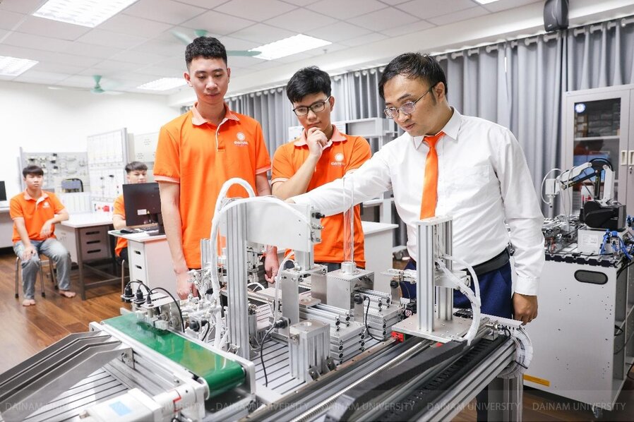 A group of men in orange shirts standing in front of a machine

Description automatically generated