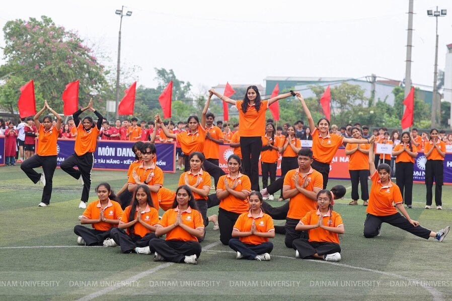 A group of people kneeling on a field with hands together

Description automatically generated